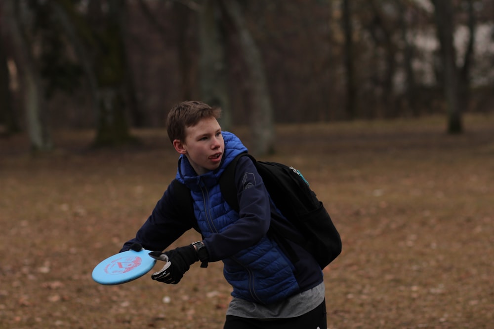 boy in blue and black jacket holding white and purple round plate