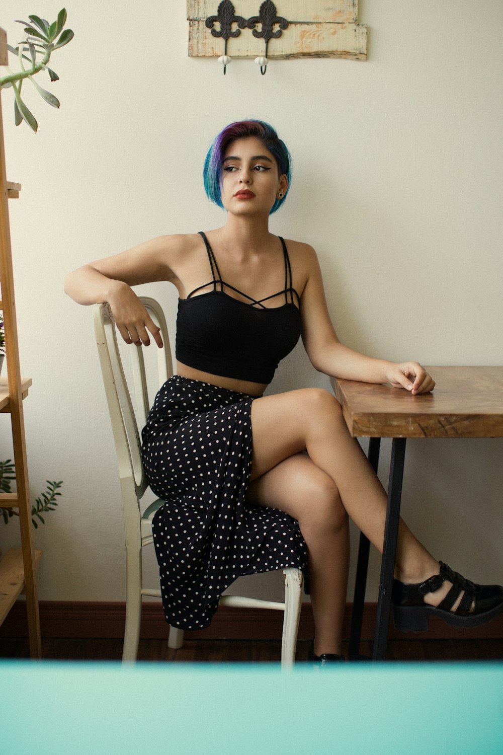 woman in black brassiere and white and black polka dots skirt sitting on chair