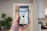 Close-up of a happy customer using a sleek smartphone in a bright, modern room.