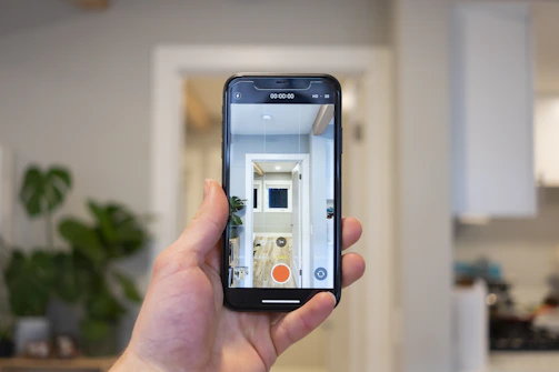 A handheld plumber camera device displaying a live feed of a pipe's interior on its screen.