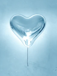Transparent bubble balloons with custom lettering floating gently against a pastel background.