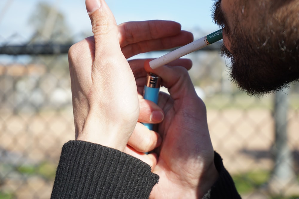 man in black knit sweater smoking cigarette