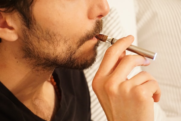 man in black shirt smoking cigaretteby Elsa Olofsson