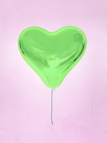 A mint green slow-rise squishy shaped like a happy avocado with a tiny heart sticker.