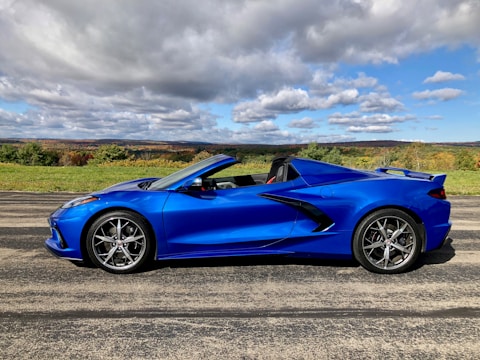 A sleek European estate car parked by a scenic countryside road.