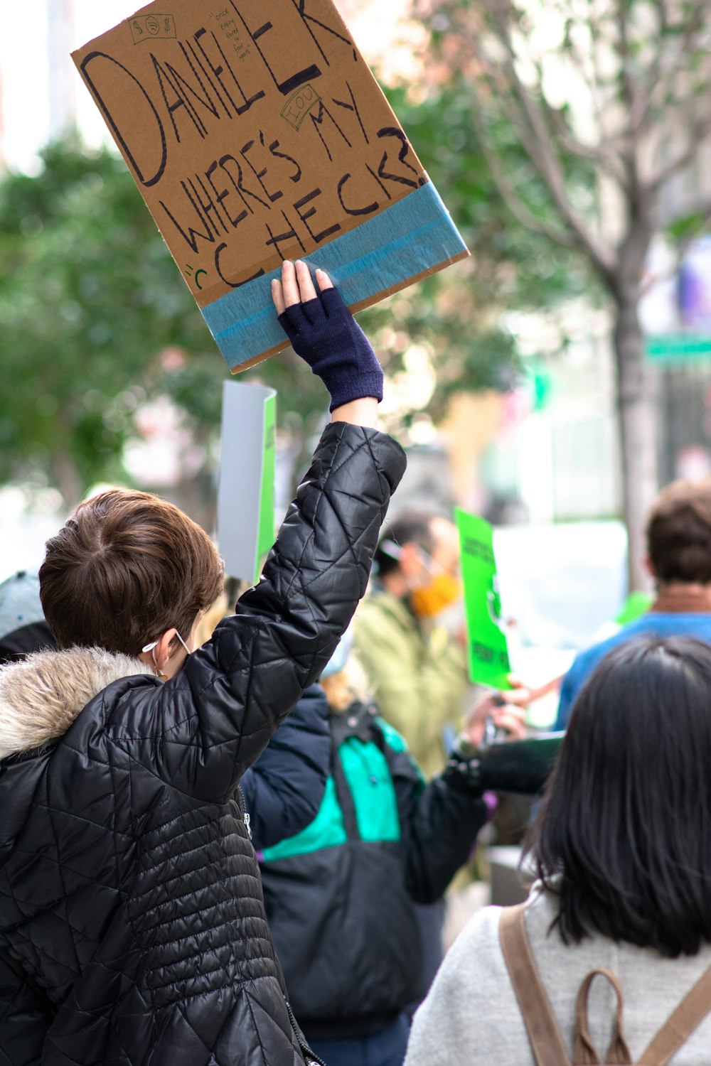 woman in black jacket holding brown wooden board