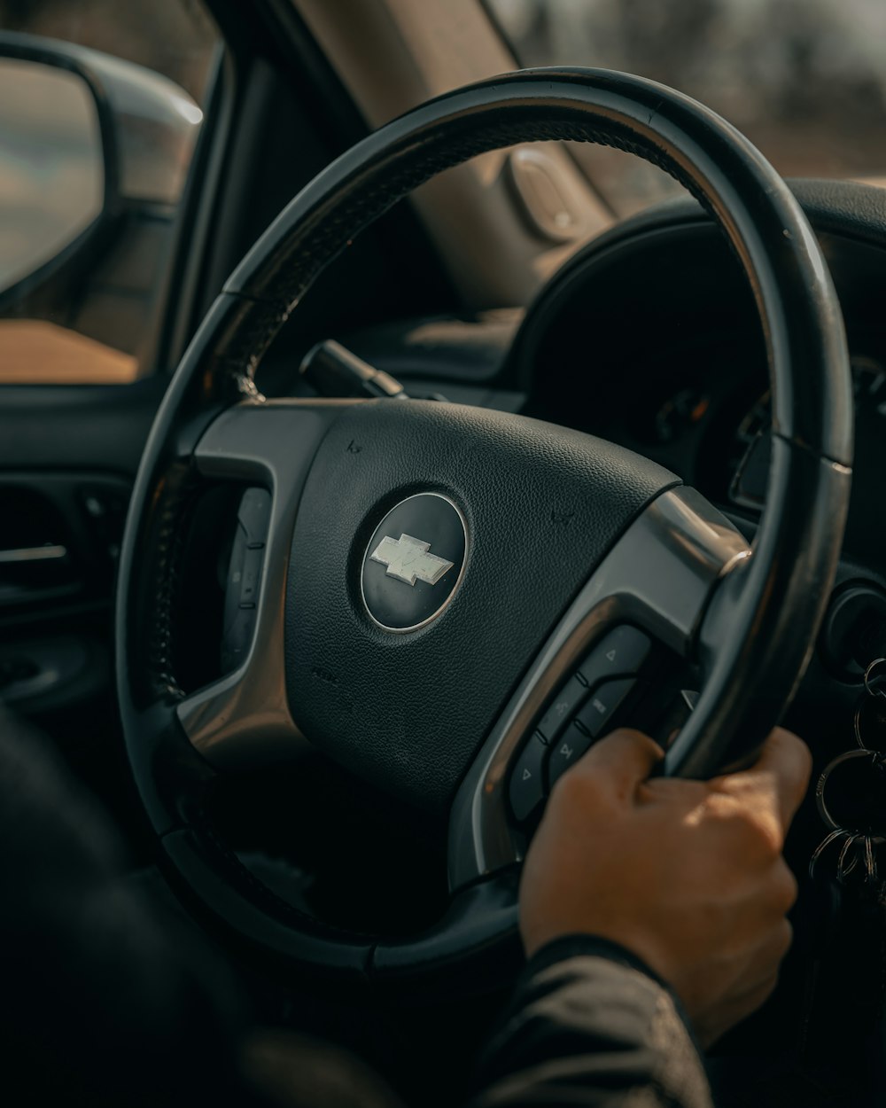 person holding black mercedes benz steering wheel