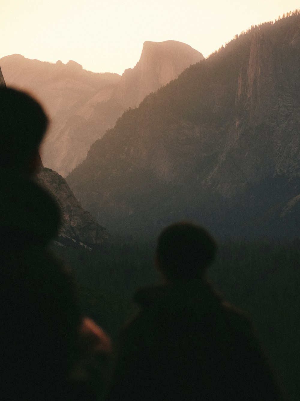 silhouette of man standing on top of mountain during daytime