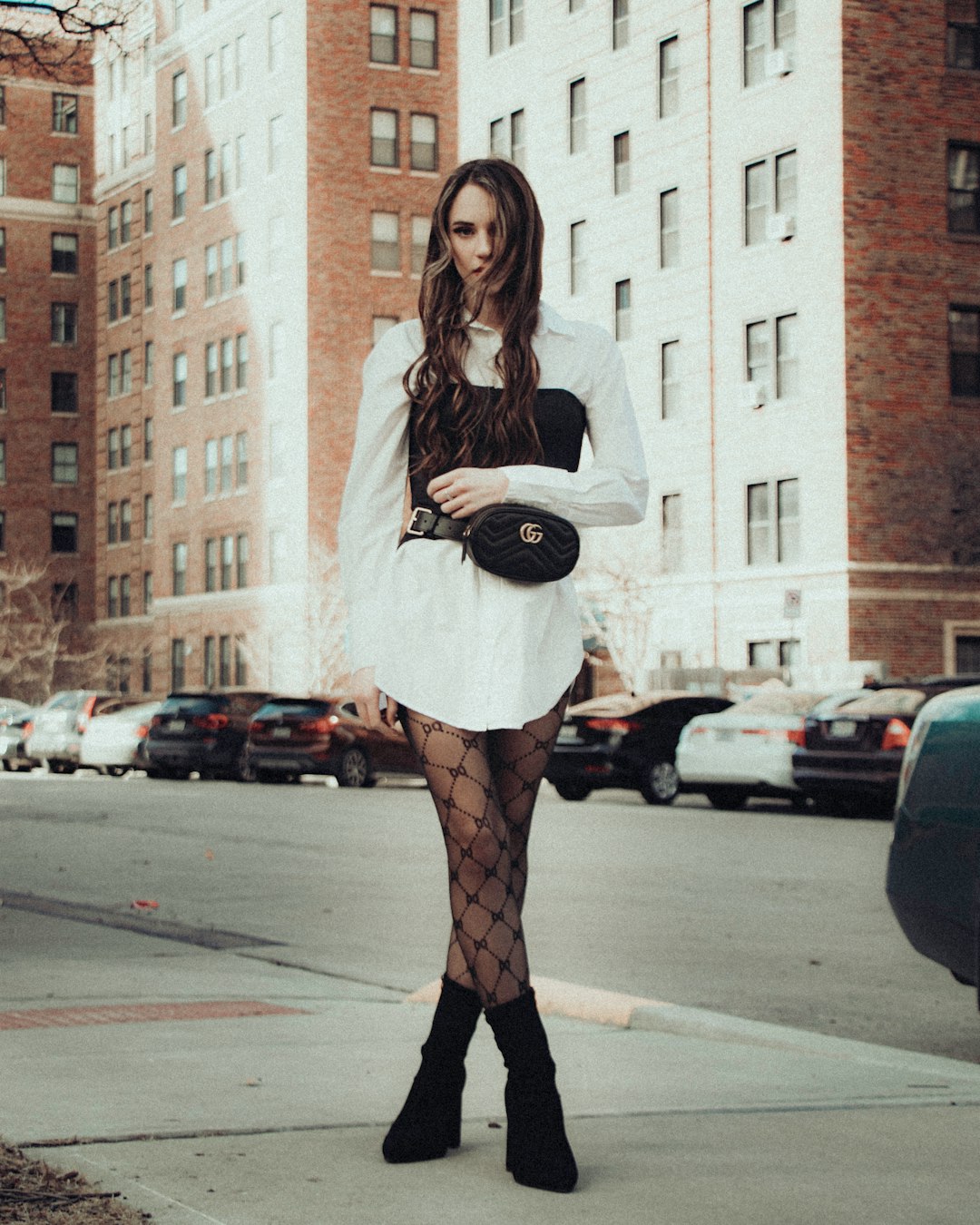 woman in white long sleeve shirt and red skirt standing on pedestrian lane during daytime