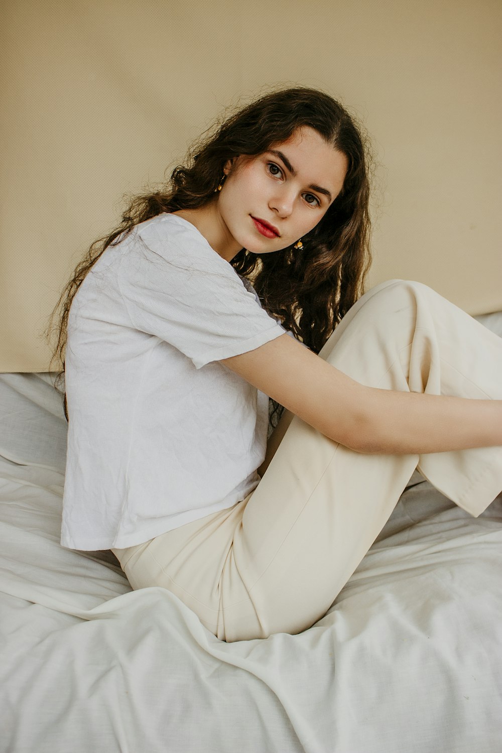 woman in white long sleeve shirt lying on bed
