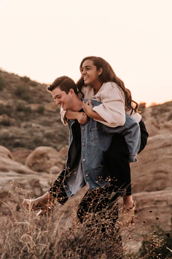 man in blue denim jacket kissing woman in white jacket during daytime