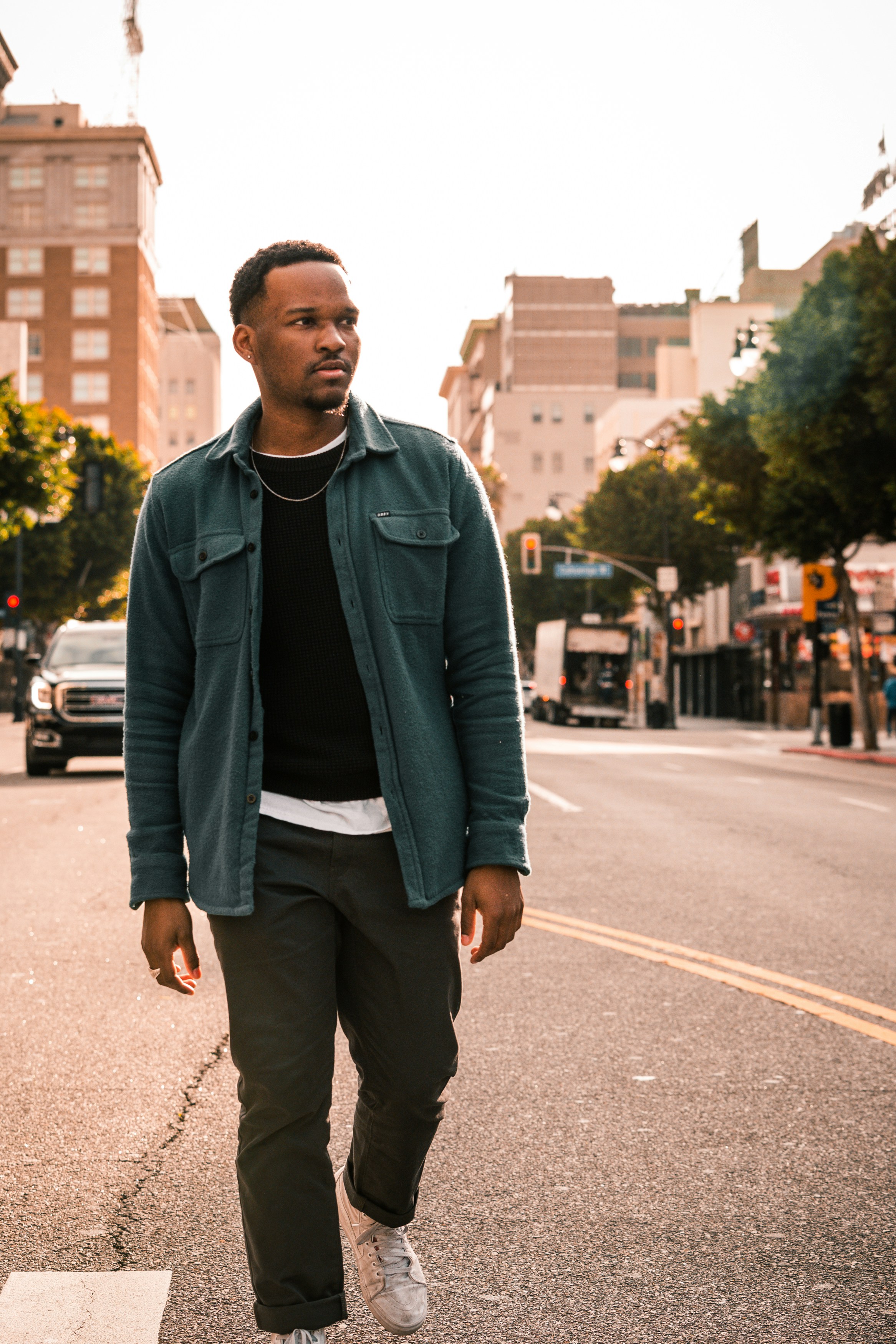 Mann in blauer Reißverschlussjacke steht tagsüber auf der Straße