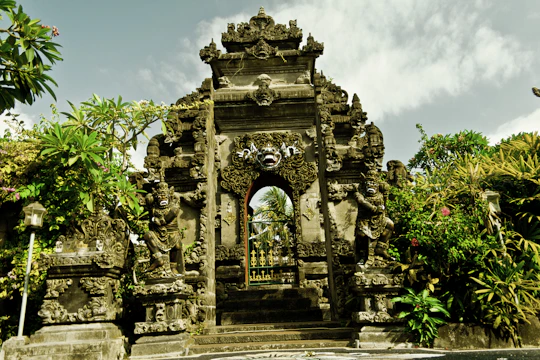 Intricate carvings on a Balinese temple entrance surrounded by lush greenery.