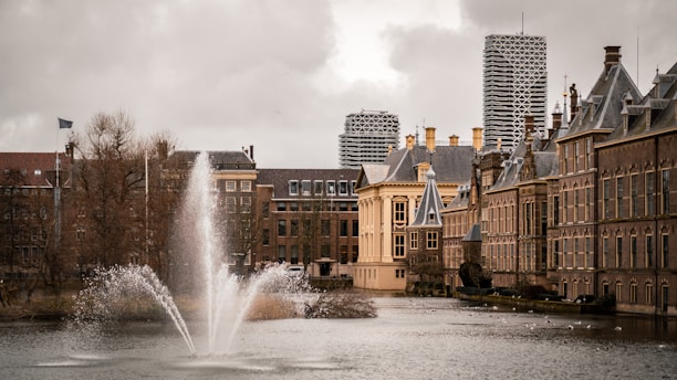 water fountain in the middle of city buildings during daytime