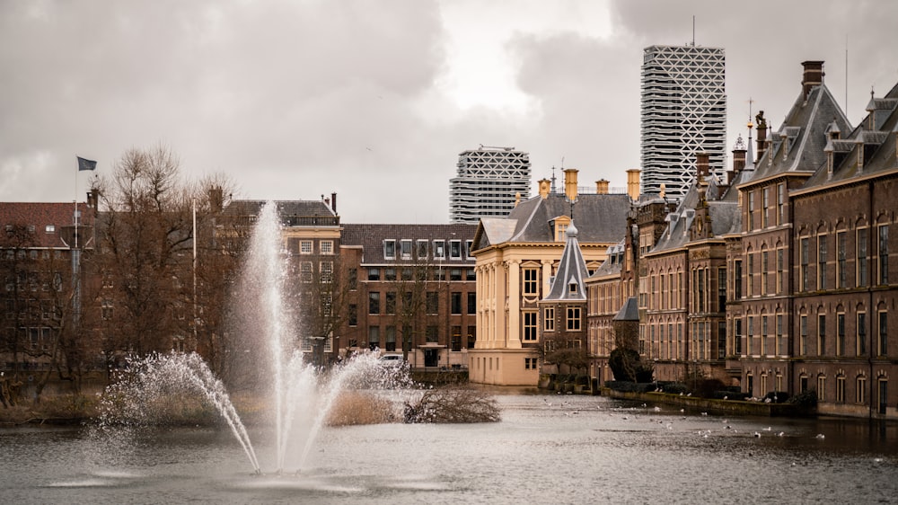 water fountain in the middle of city buildings during daytime