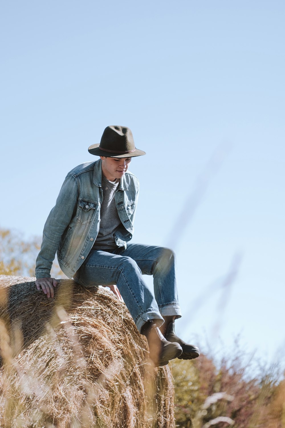 woman in blue denim jacket and blue denim jeans sitting on brown horse during daytime