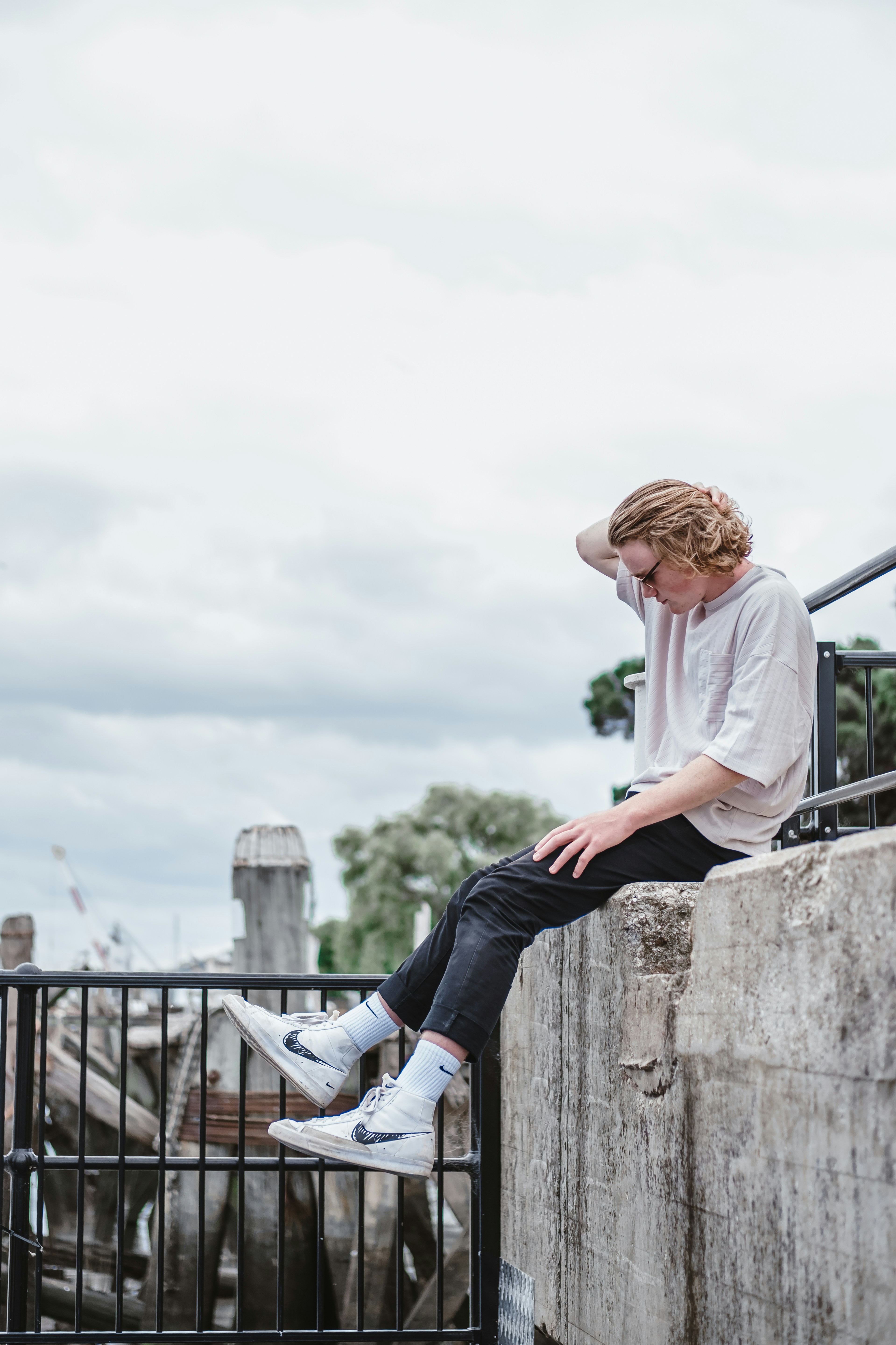 Woman in white long sleeve shirt and blue denim jeans sitting on gray ...