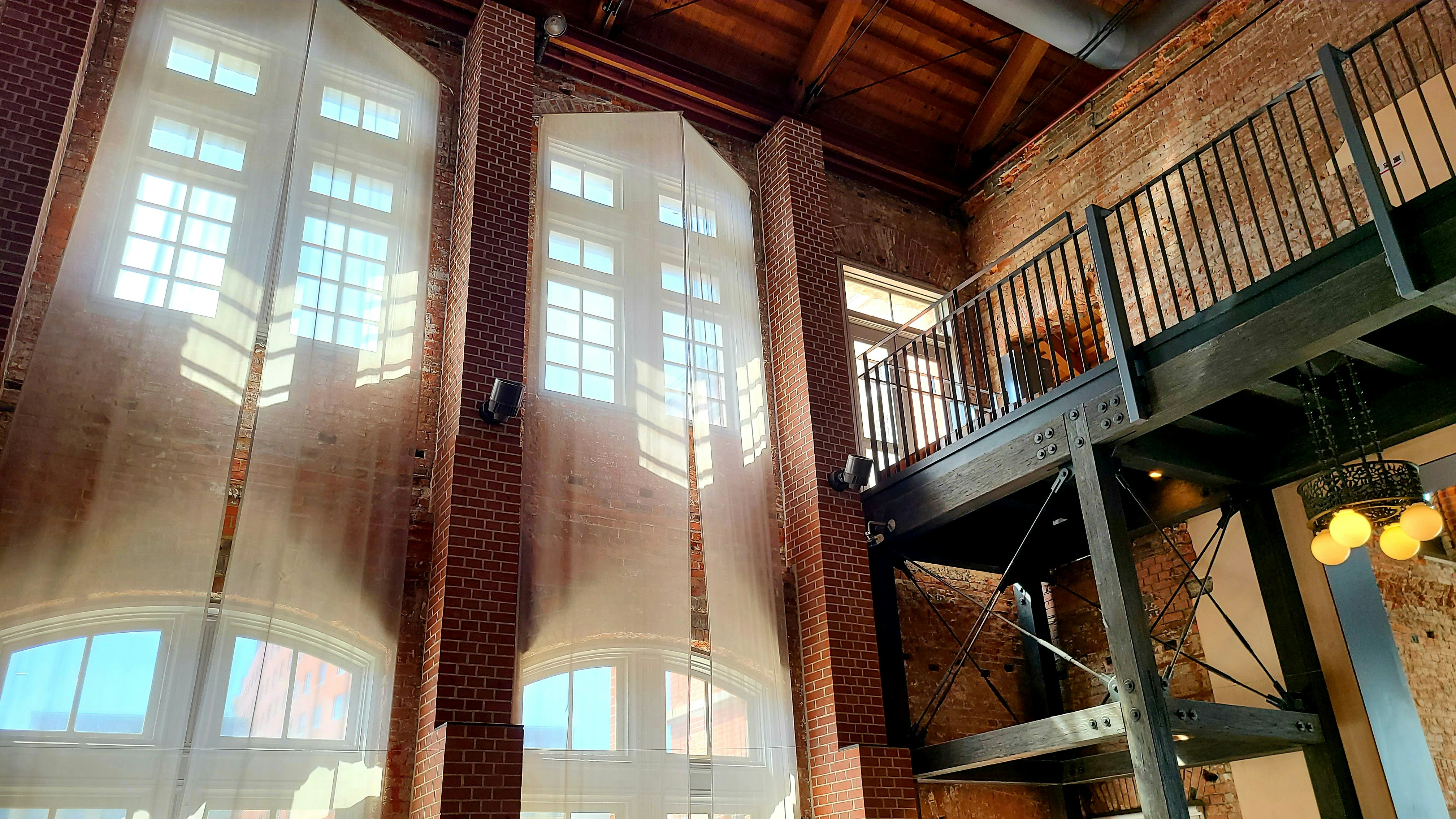 Industrial-style open-plan living space with exposed brick walls and mezzanine