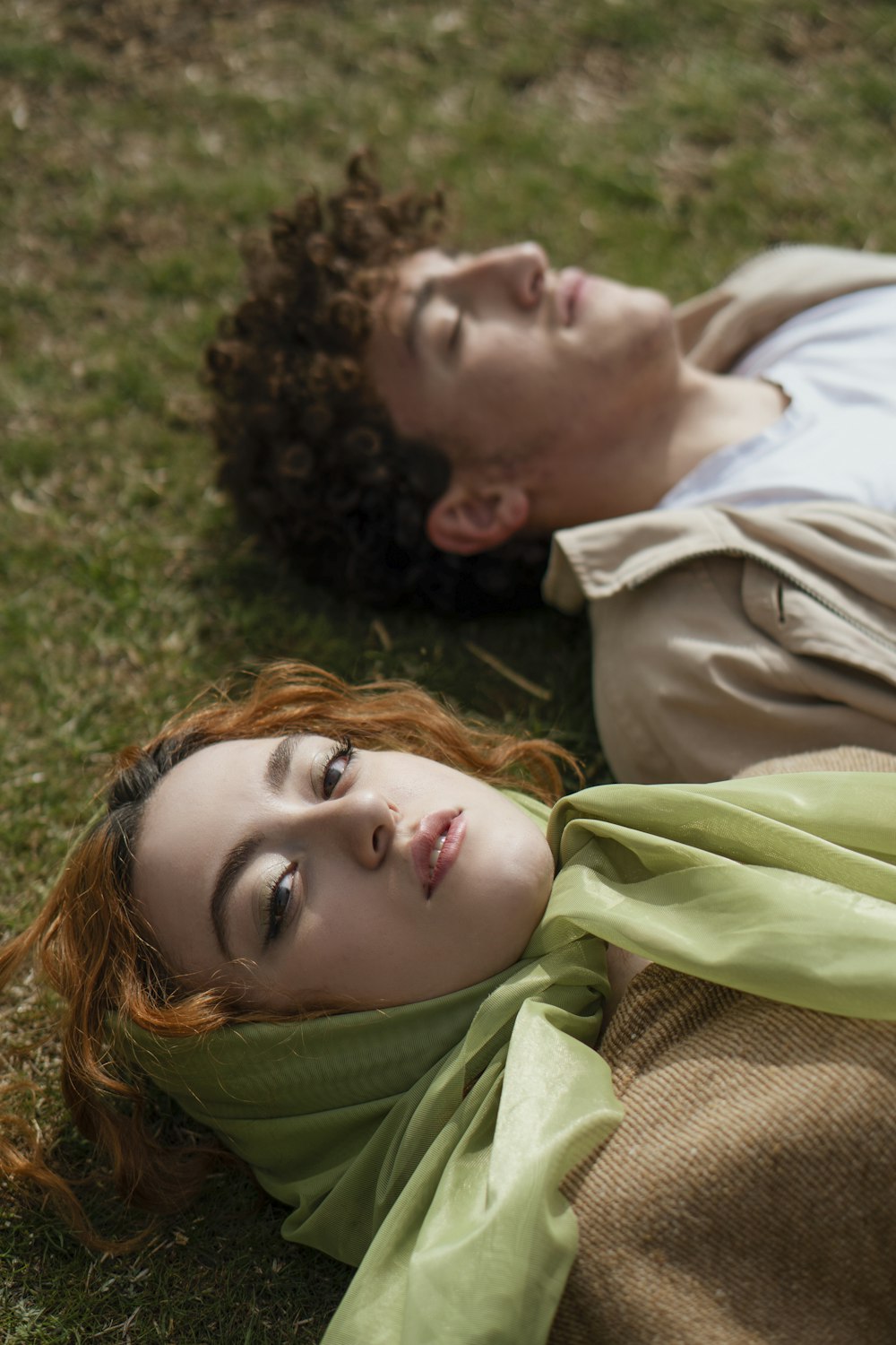 woman in green scarf lying on green grass