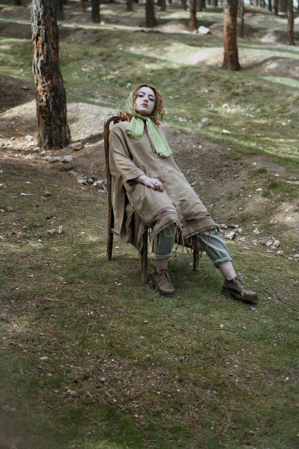 a woman sitting in a chair in the woods