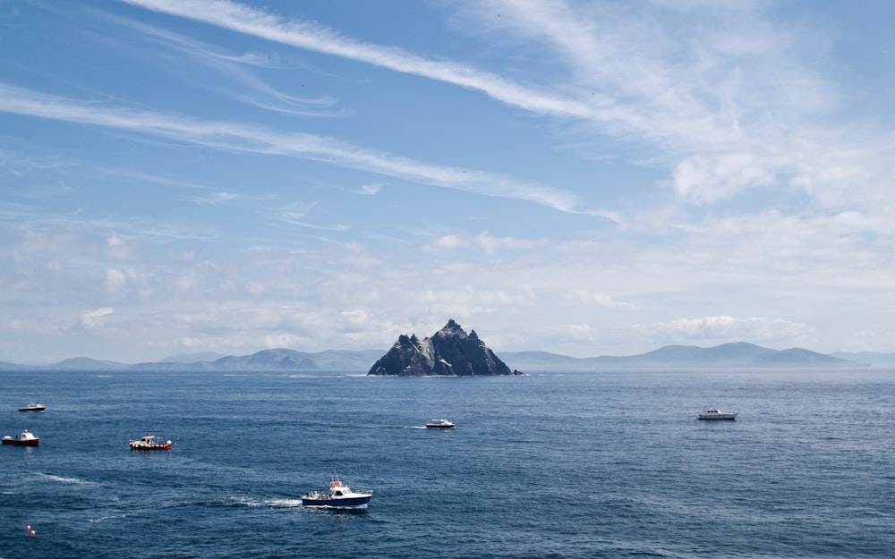 white and blue boat on sea under blue sky during daytime