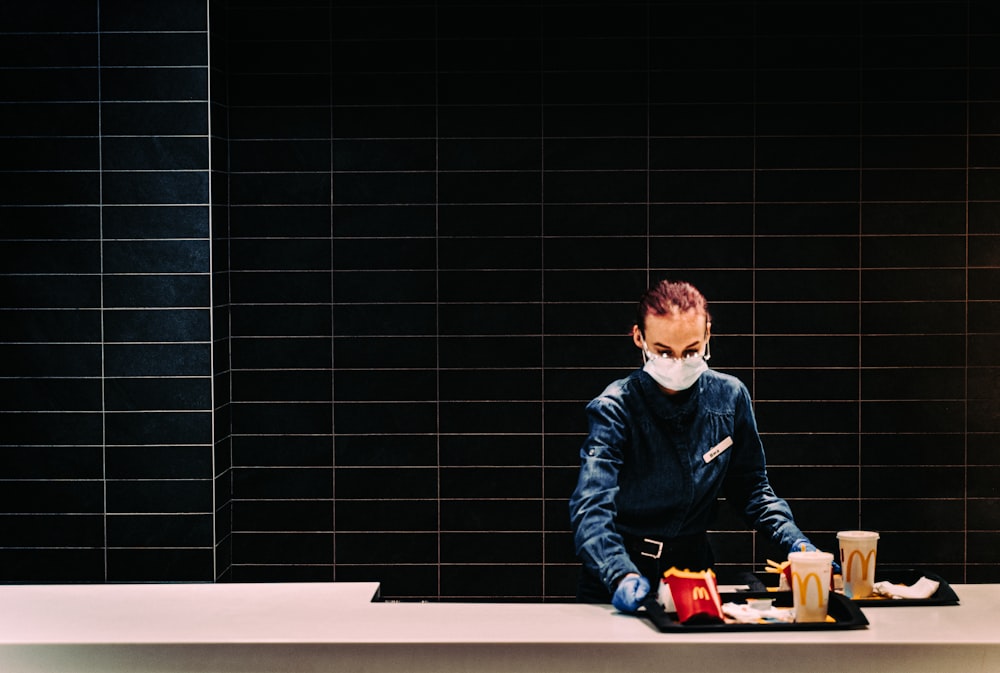 boy in black jacket sitting on white table