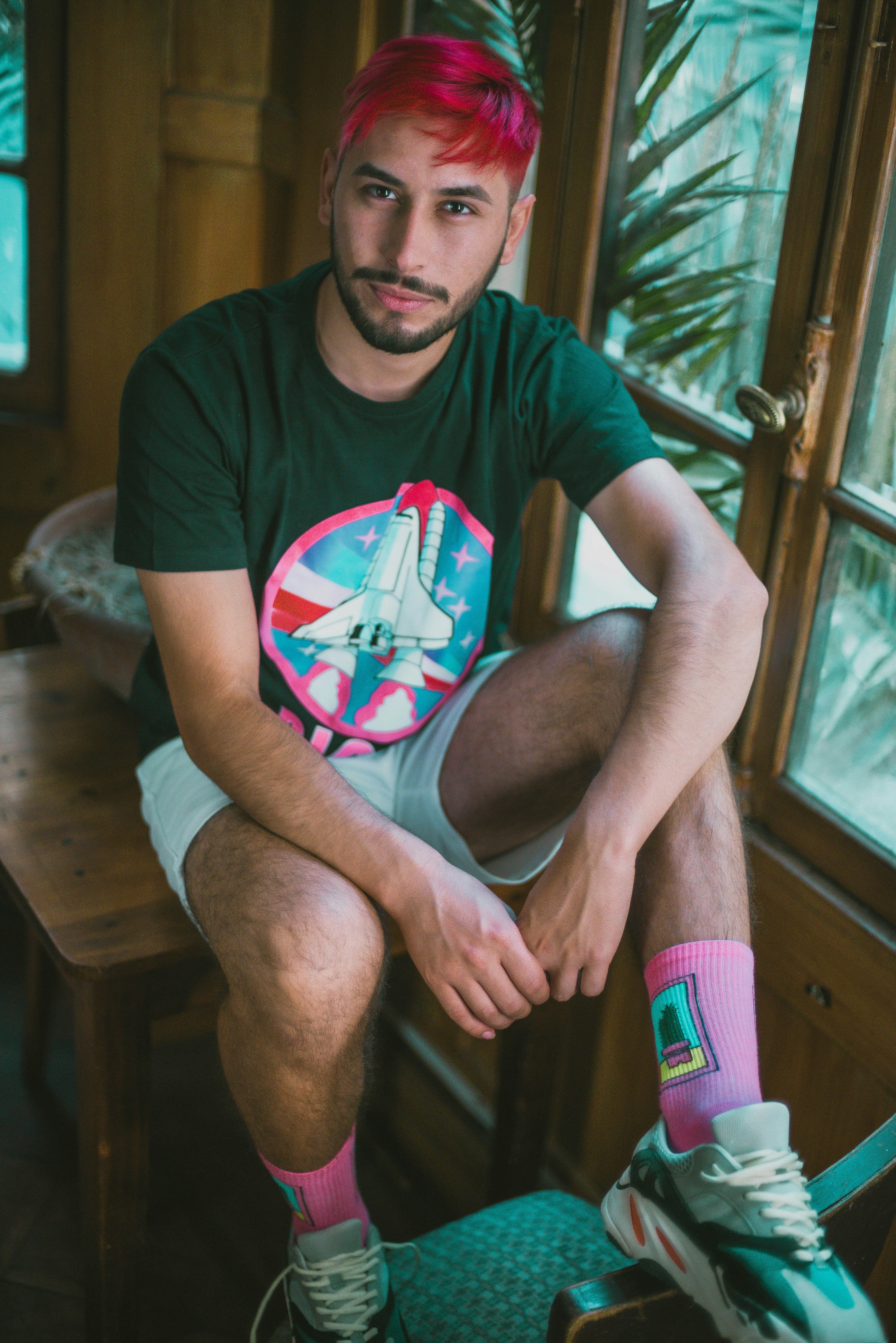 man in black crew neck t-shirt sitting on brown wooden chair