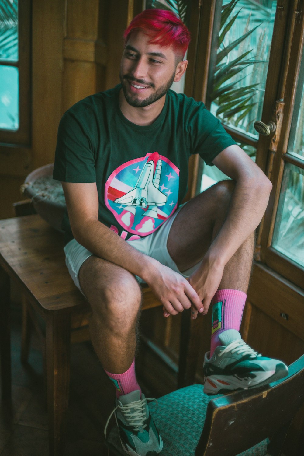 man in red crew neck t-shirt sitting on brown wooden chair