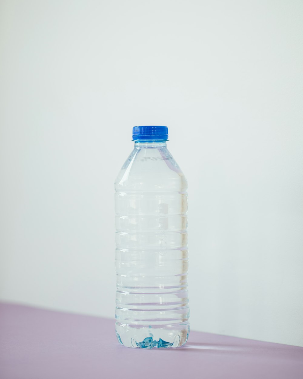 Botella de plástico transparente sobre mesa blanca