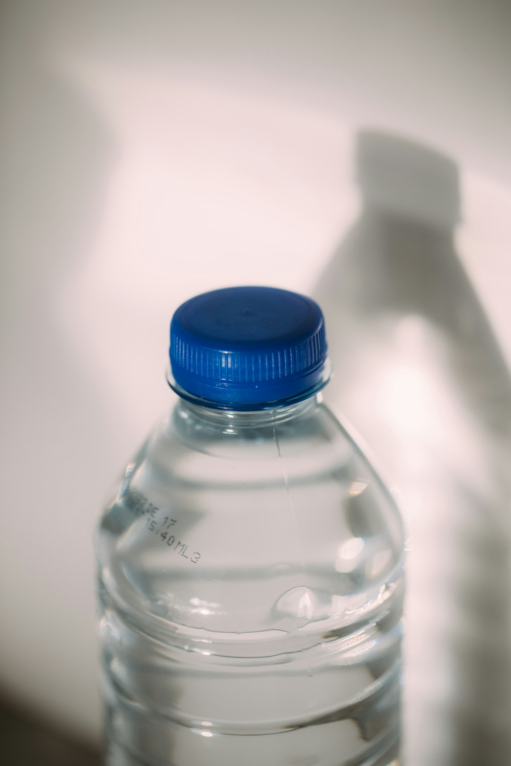 Botella de plástico transparente con tapa azul