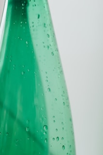 green plastic bottle with water droplets