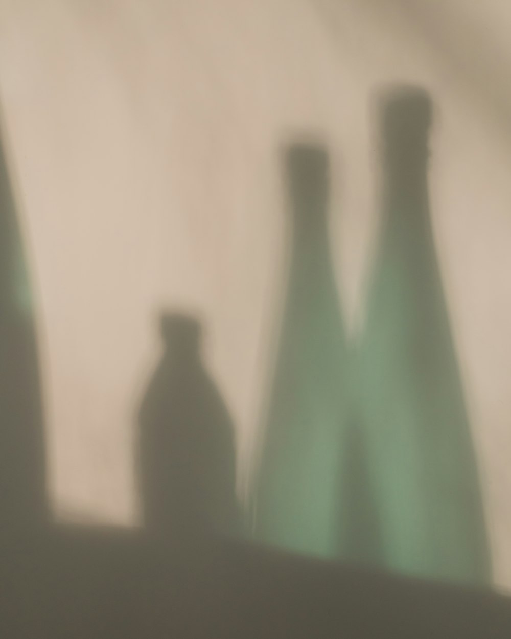 green glass bottle on white table