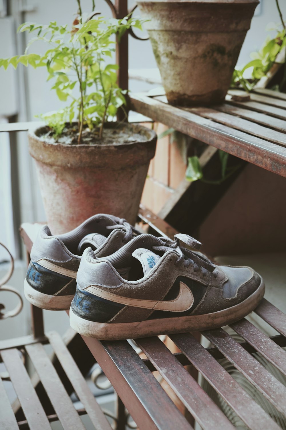 black and white nike athletic shoes on brown wooden bench