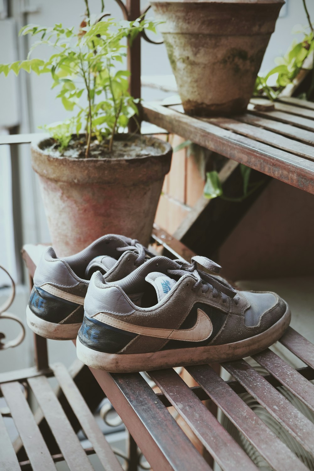 Chaussures de sport Nike noir et blanc sur banc en bois marron