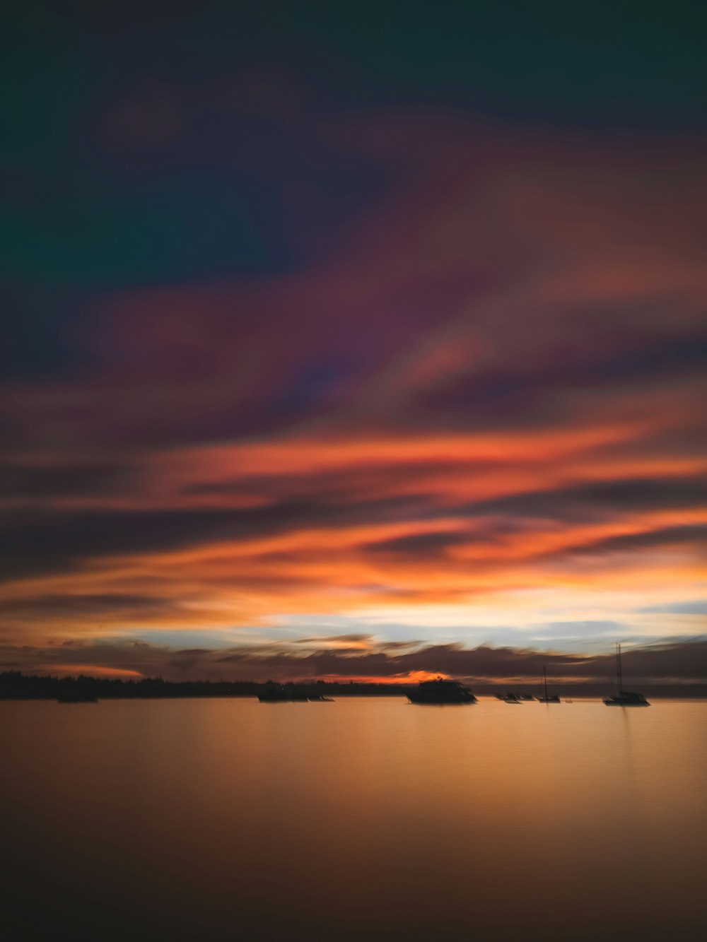 Cuerpo de agua bajo cielo nublado durante la puesta del sol