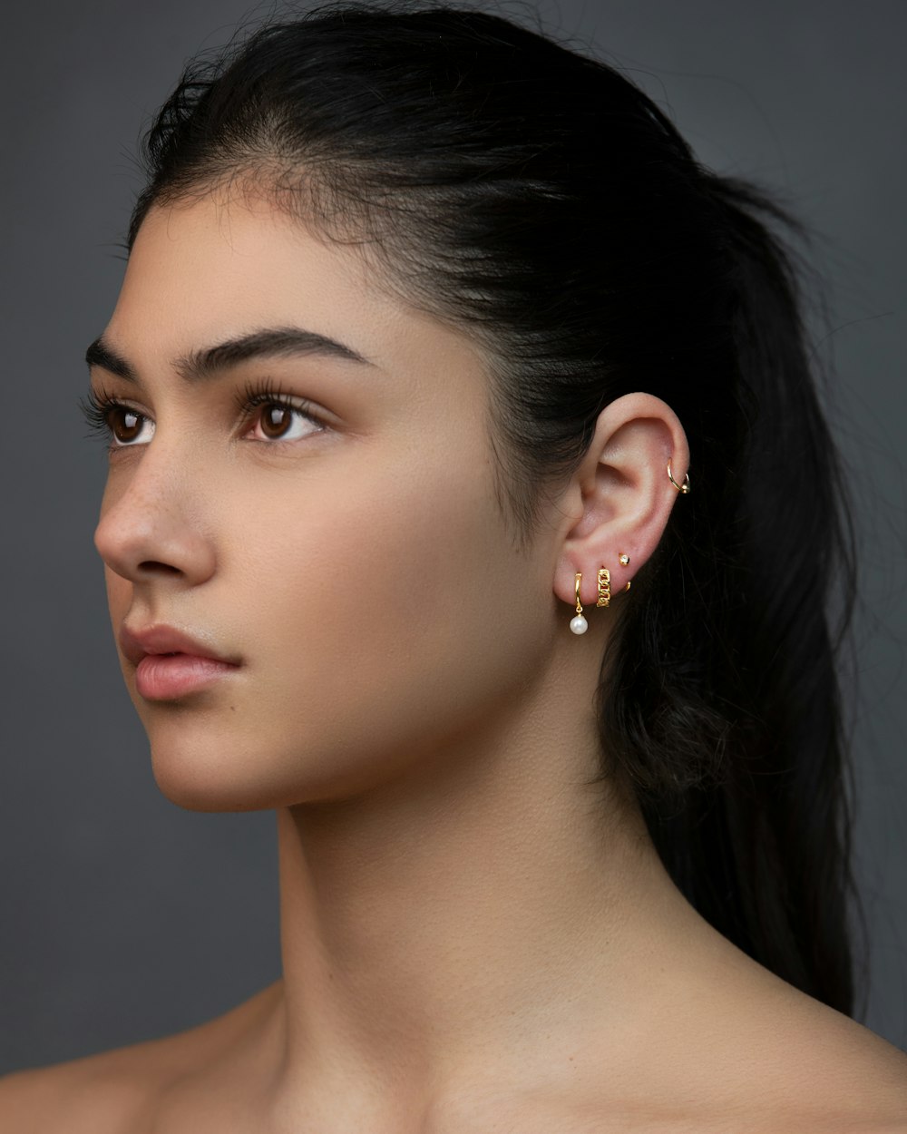 woman with silver and diamond stud earrings