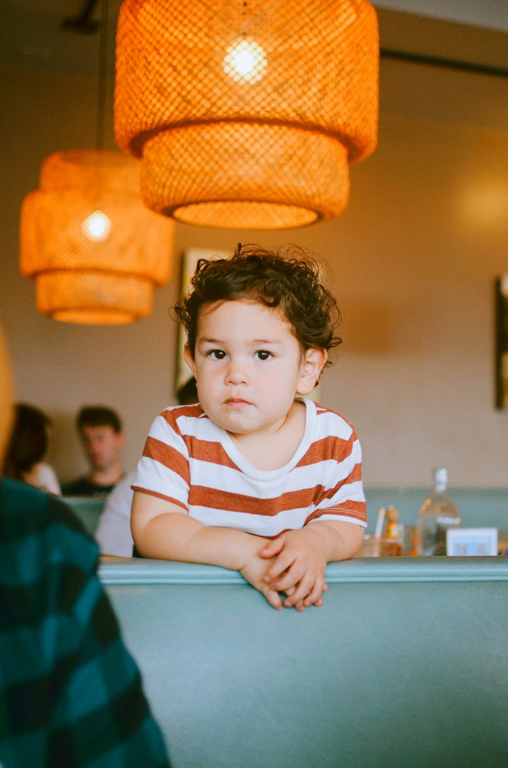 boy in white and red striped long sleeve shirt sitting on chair