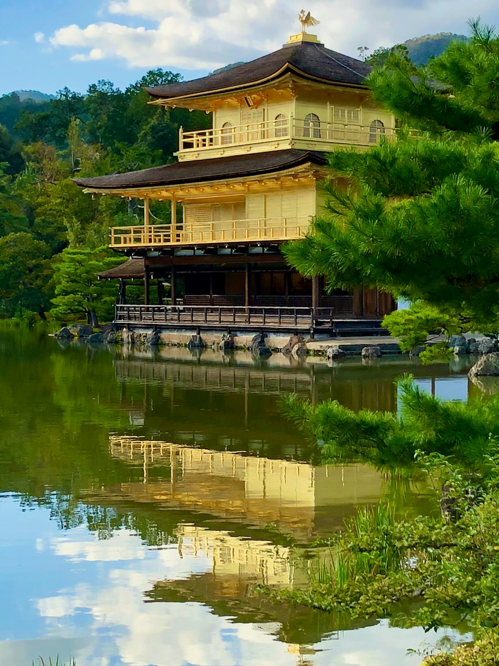 brown and white wooden house near body of water during daytime