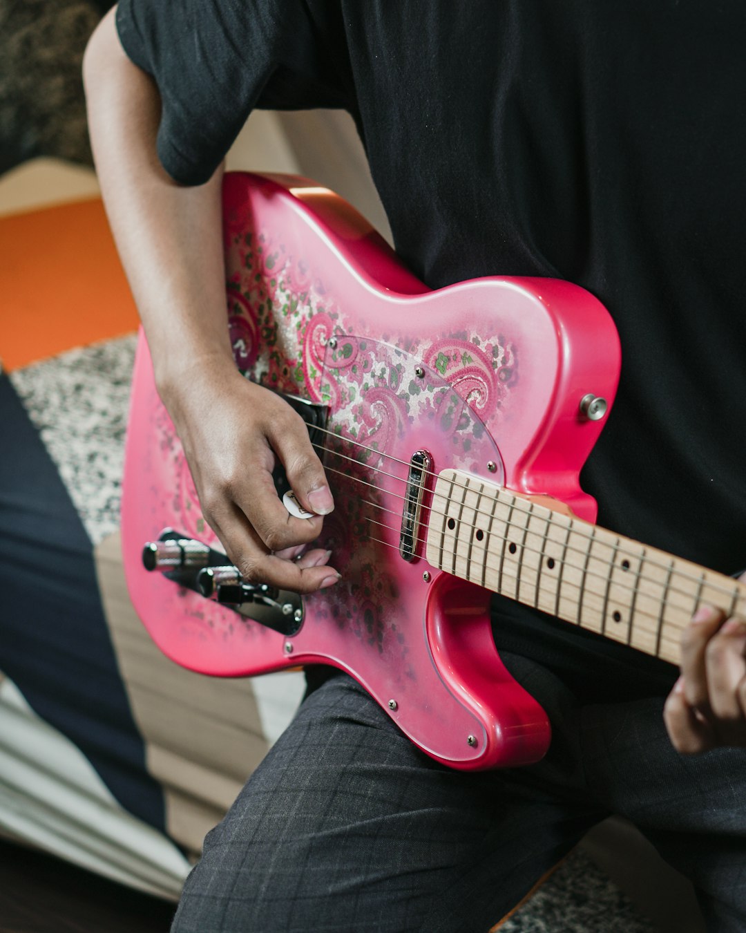 person playing red electric guitar