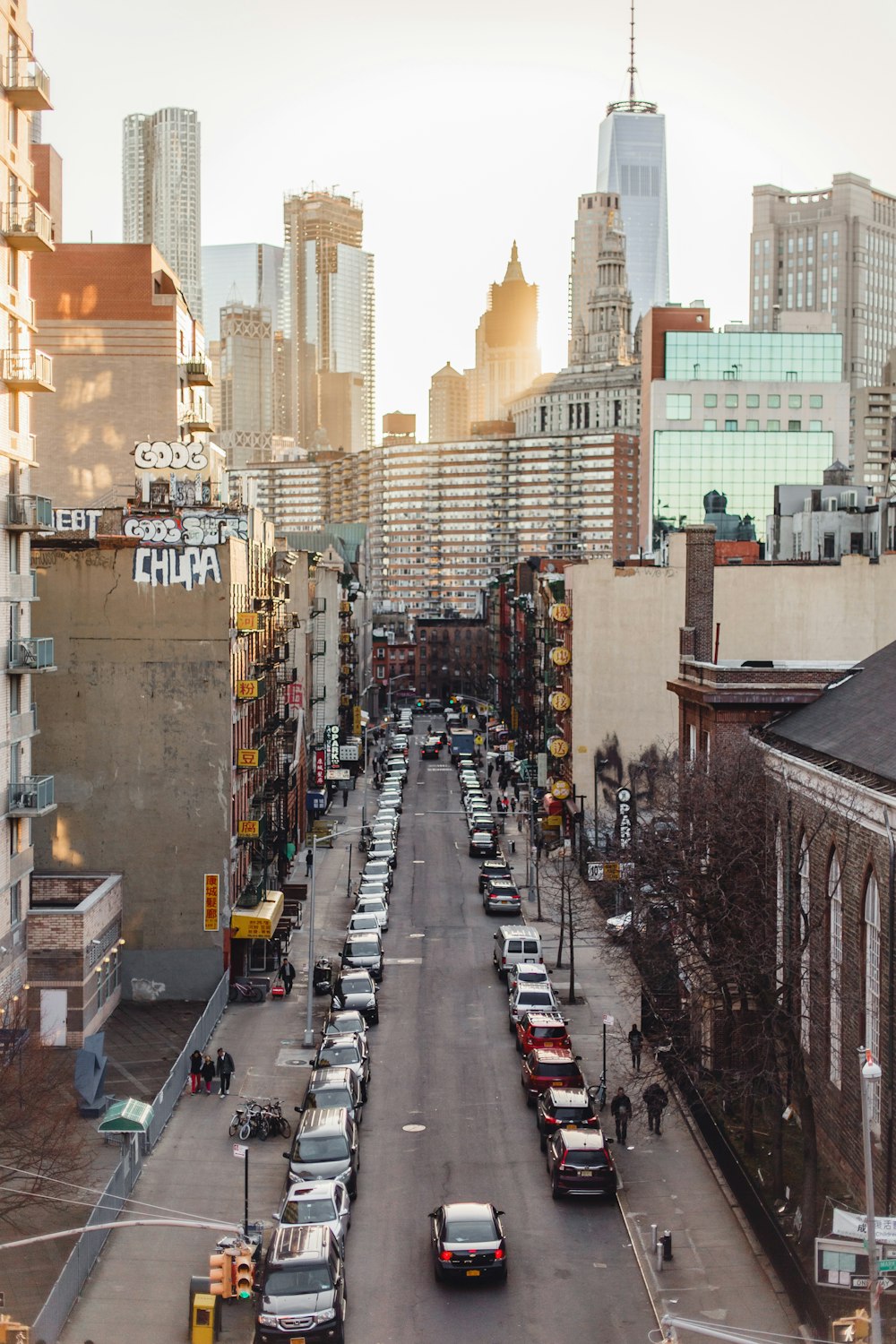 cars on road between high rise buildings during daytime