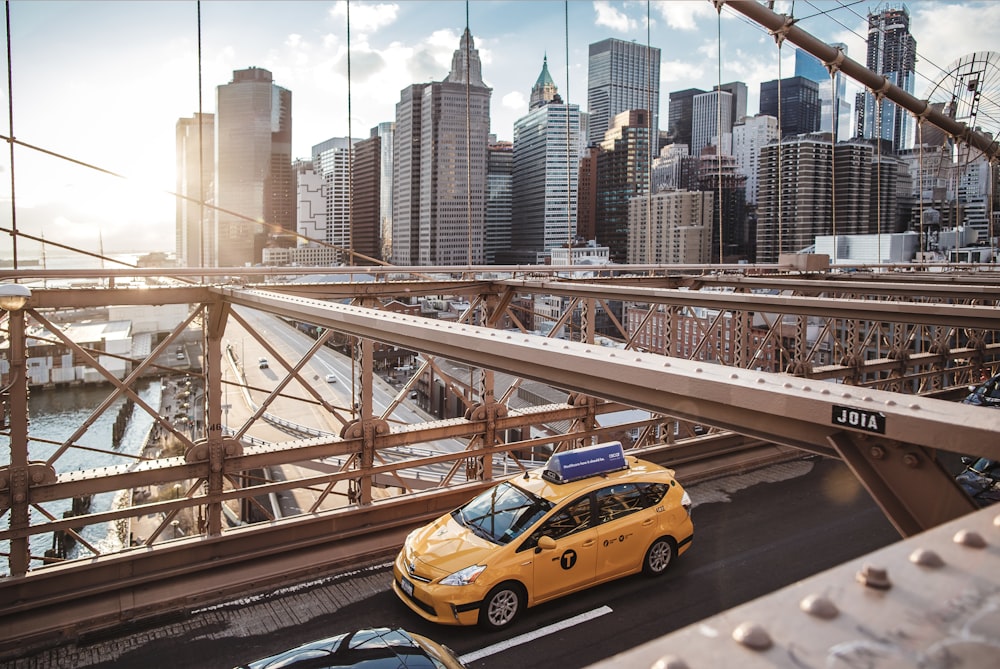 日中の橋の上の黄色いタクシー