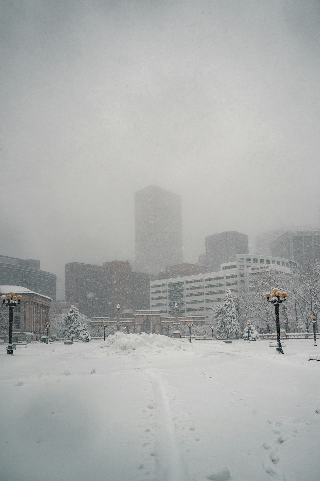 snow covered road near city buildings during daytime