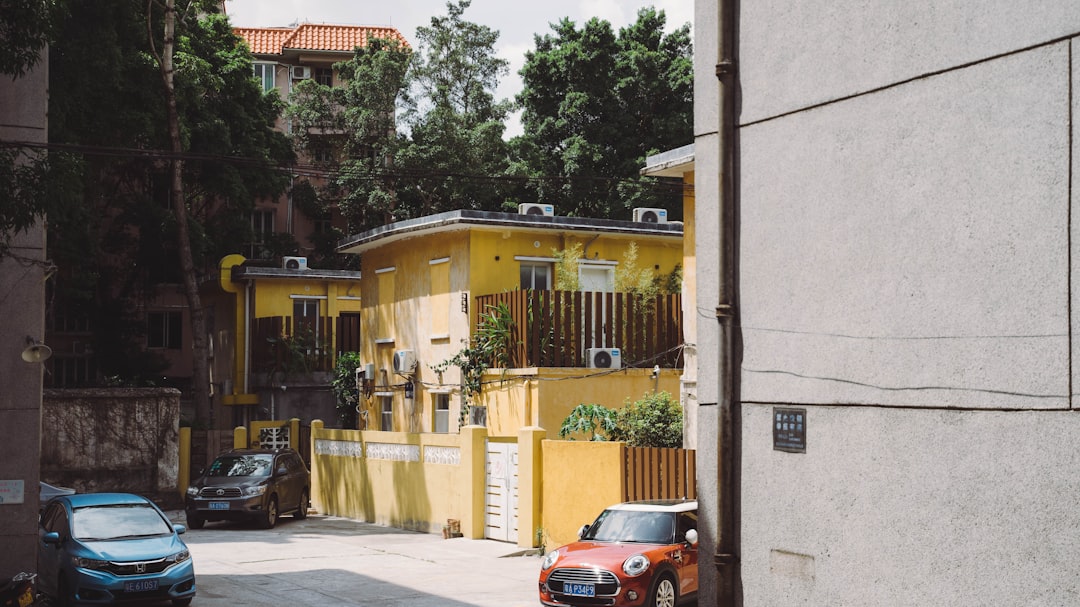 red car parked beside yellow building