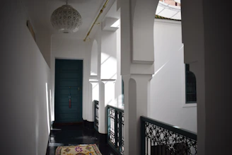 A narrow hall runner rug with delicate floral patterns guiding the way down a bright corridor.