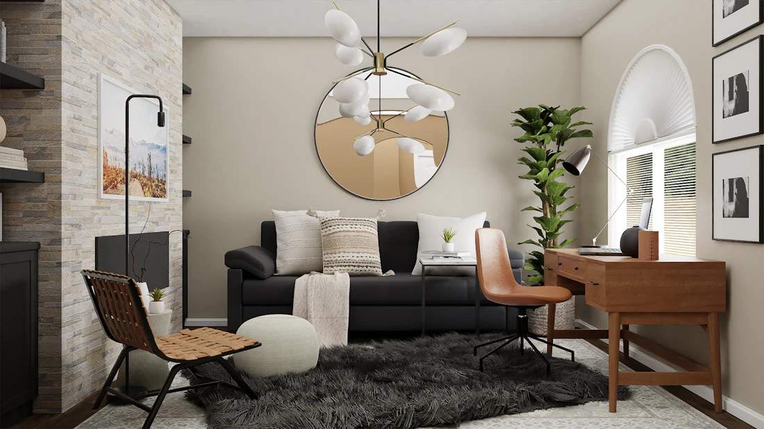 Dark, styled showroom corner with a black sofa, tan leather chair and a brass-framed mirror