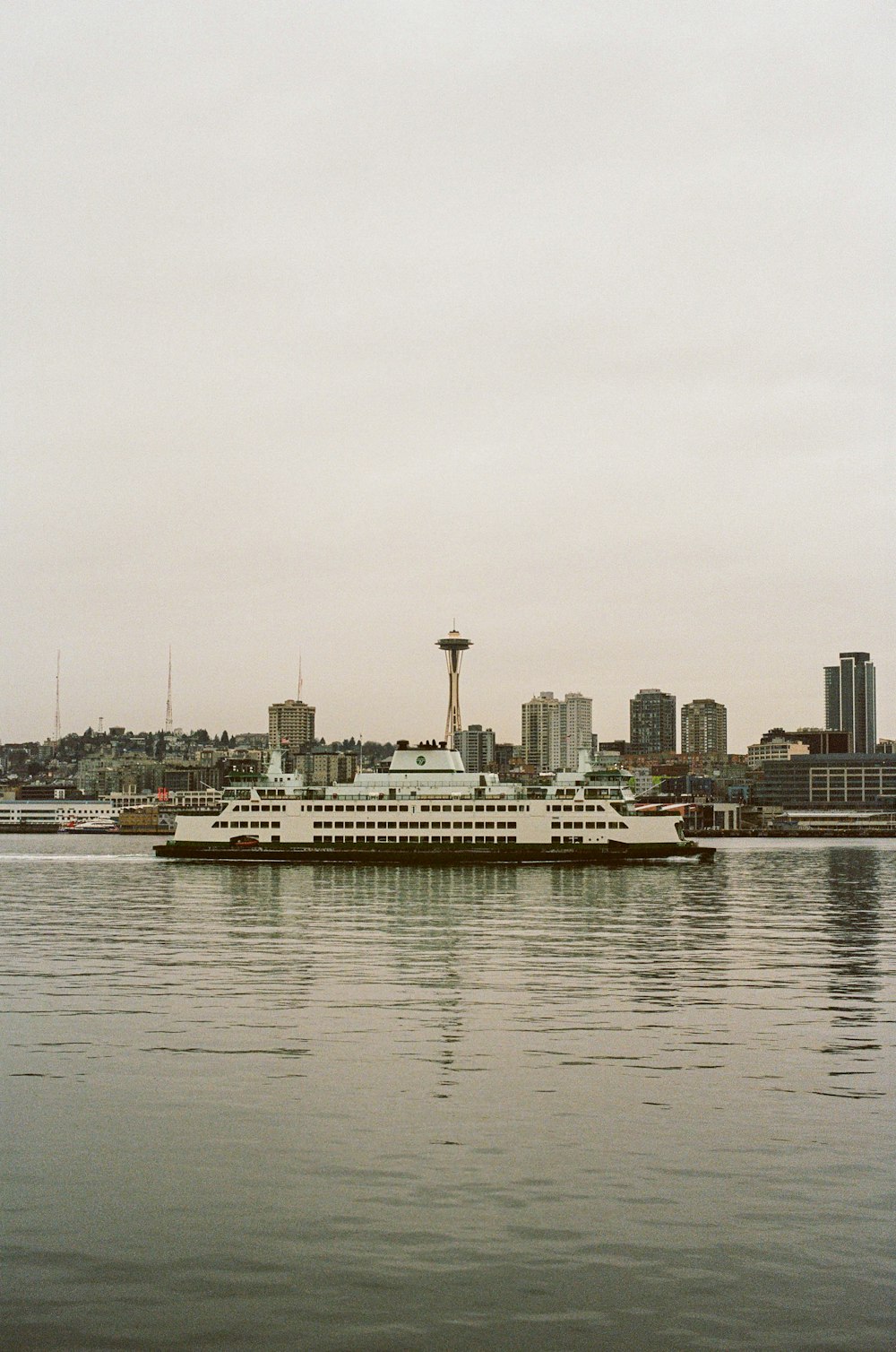 white and black ship on sea near city buildings during daytime