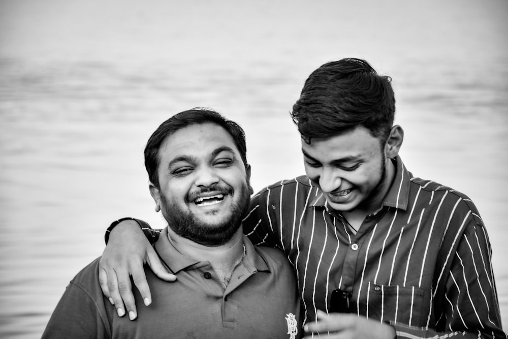 man in polo shirt smiling beside woman in striped shirt