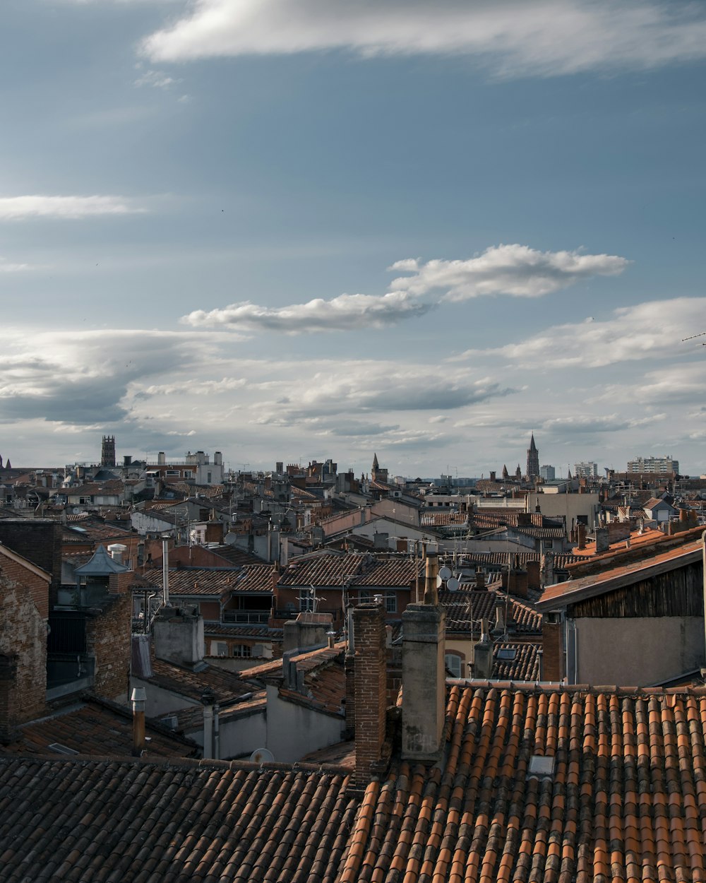 Edificios de hormigón marrón y blanco bajo nubes blancas durante el día