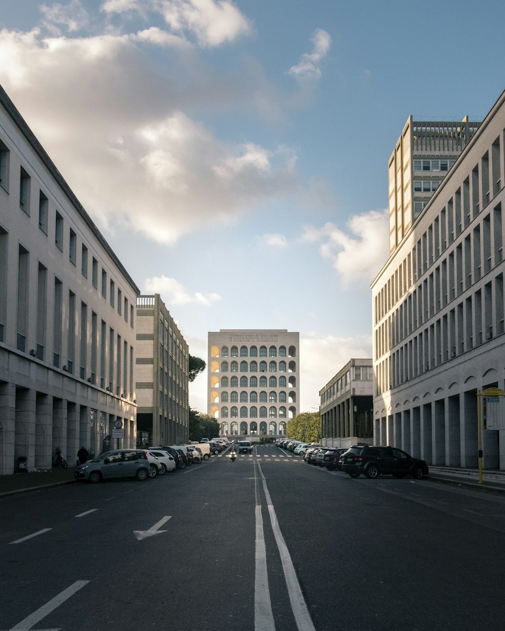 cars parked in front of white concrete building during daytime