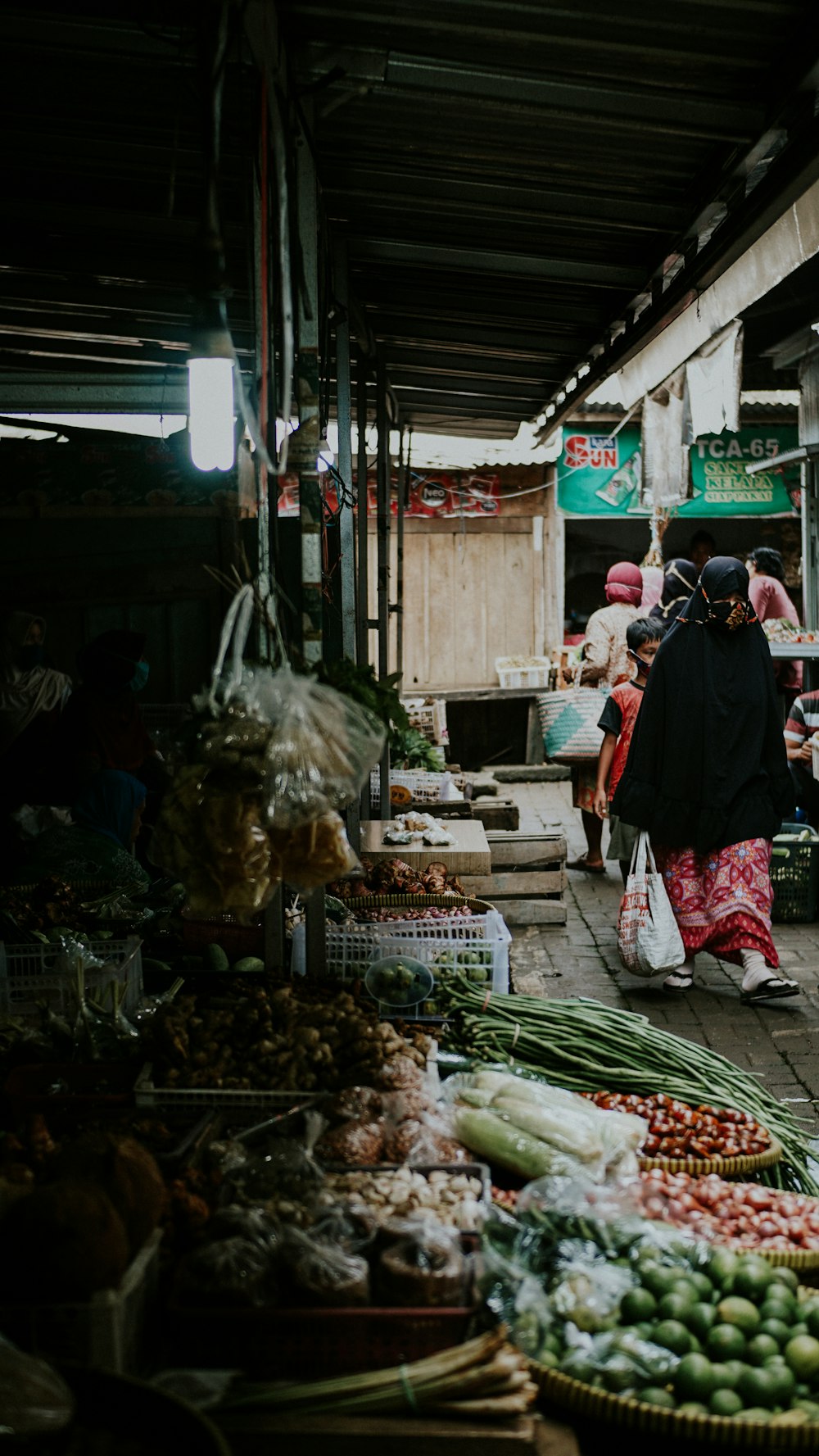 persone che camminano sul mercato durante il giorno